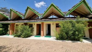 A building with multiple rooms, each with a thatched roof and green trim.