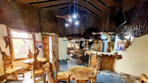 A rustic interior with wooden furniture and a stone wall.