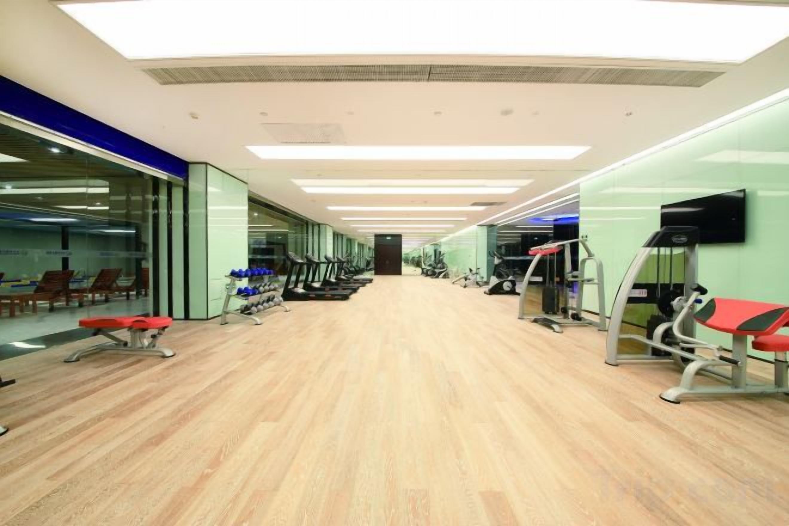 A gym with exercise equipment, a reception area, and a glass wall.