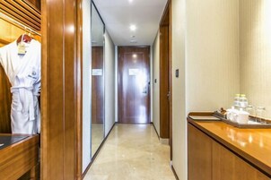 Un pasillo de hotel con paneles de madera, una recepción con servicios y una bata colgada en un perchero.