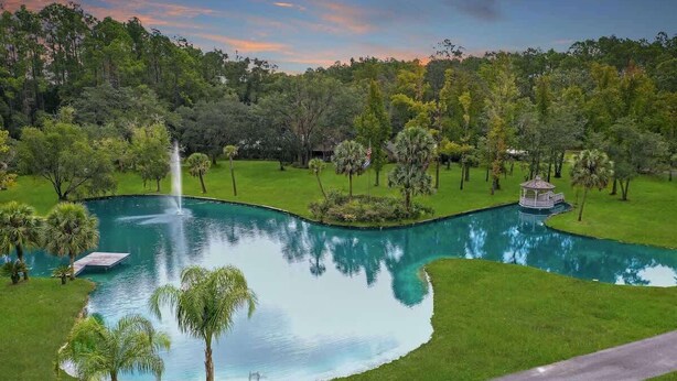 Ein angelegter Garten mit Teich, Laube und Springbrunnen.