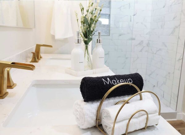 A bathroom with a white marble sink, gold faucets, and a towel rack holding two towels. - A Serene Cottage Escape on 7 Acres St Augustine (St. Augustine)