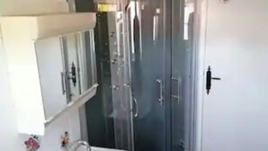 Une salle de bain avec une douche à parois de verre, un lavabo et un meuble de rangement.
