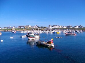 A harbor with multiple boats docked, surrounded by houses and a clear sky. - Studio, a 5-minute walk from the beach (TREGUNC)