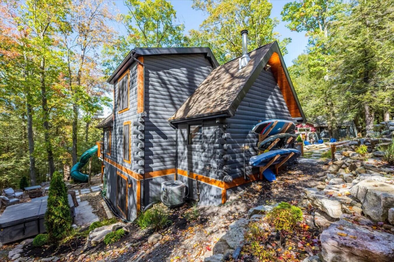 Eine Blockhütte mit steilem Dach, einem Schornstein und einer kleinen Veranda.