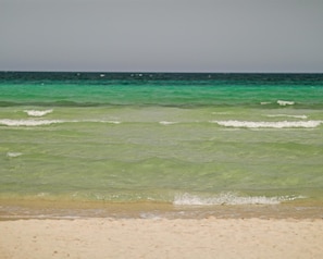 Uma praia com águas turquesa cristalinas e uma faixa de areia.