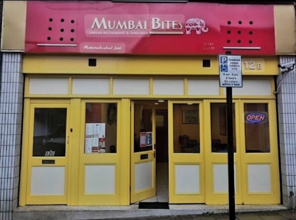 A yellow storefront with a sign reading "Mumbai Bites Indian Restaurant & Takeaway." - Self catering flat, parking, 4 min walk beach, 3 min shops. Car ferry discount. (Sandown)