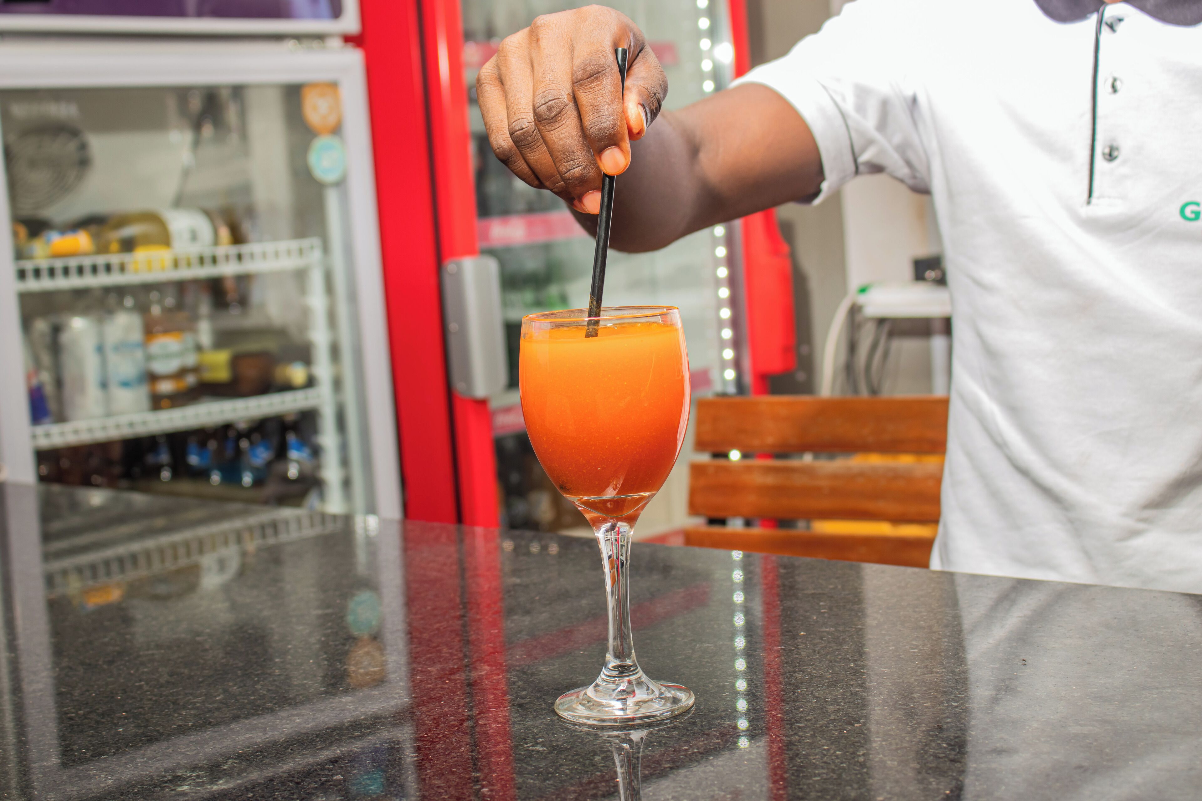 A bartender pouring a drink into a glass.