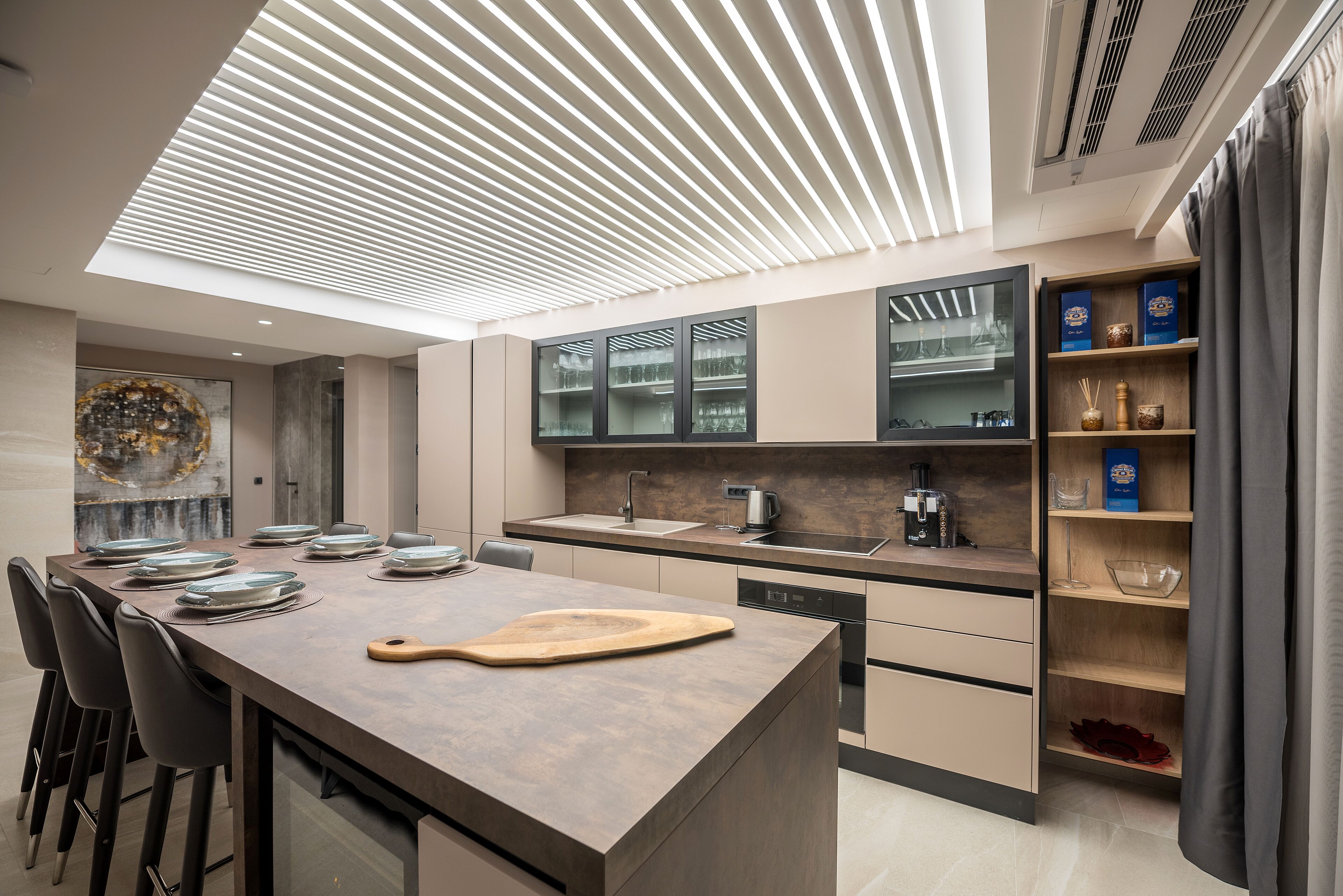 Une cuisine moderne dotée d’un îlot central, de meubles encastrés et d’une lucarne.