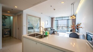 Een moderne keuken met een centraal eiland, een inbouwspoelbak, en een eetgedeelte met een tafel en stoelen.