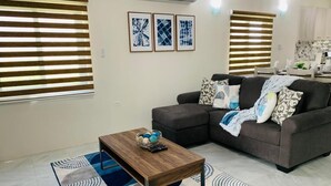 Una sala de estar con un sofá, una mesa de centro y un tapiz estampado.