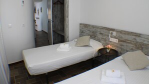 A small, clean room with a single bed, a bedside table, and a mirror. - Agi Porthos 111 Apartamento for rent in Roses Girona. (Roses)
