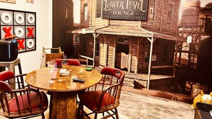 A room with a wooden table, chairs, and a mural of a 3R Ranch Lower Level Lounge. - Brown County At It's Best Beautiful Cozy meticulous clean LG Game Room arcade! (Nashville)