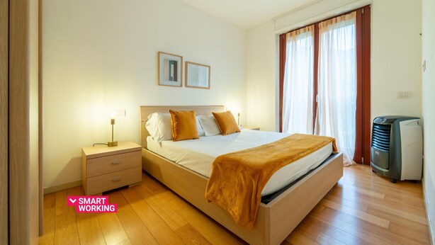 Une chambre à coucher avec un lit, une table de chevet et un radiateur.