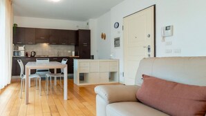 Un appartement moderne comprenant un coin repas, une kitchenette et un salon avec un canapé.