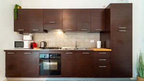 Une cuisine moderne avec des meubles de couleur brun foncé, un four encastré, un four à micro-ondes et un évier.
