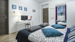 Une chambre à coucher moderne, équipée d’un lit, d’un bureau et d’une télévision.