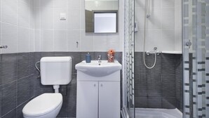 A modern bathroom with a toilet, sink, and shower. - Double or twin room  (Pula)