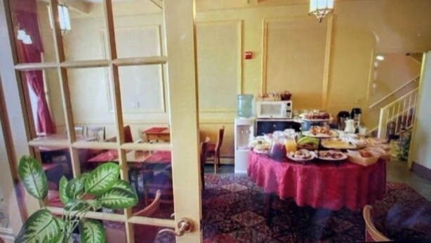 Ein Zimmer mit Essbereich, ausgestattet mit einem Tisch, der für eine Mahlzeit gedeckt ist, einer Mikrowelle und einem Wasserspender.