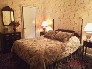 Ein Schlafzimmer mit einem Bett, einem Schminktisch und zwei Nachttischlampen.