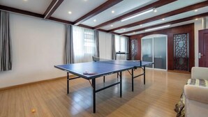 Ein geräumiger Raum mit einem Tischtennischreibtisch, Holzboden und einem modernen Deckenstil.