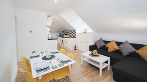 A modern apartment with a dining area, kitchen, and living space.