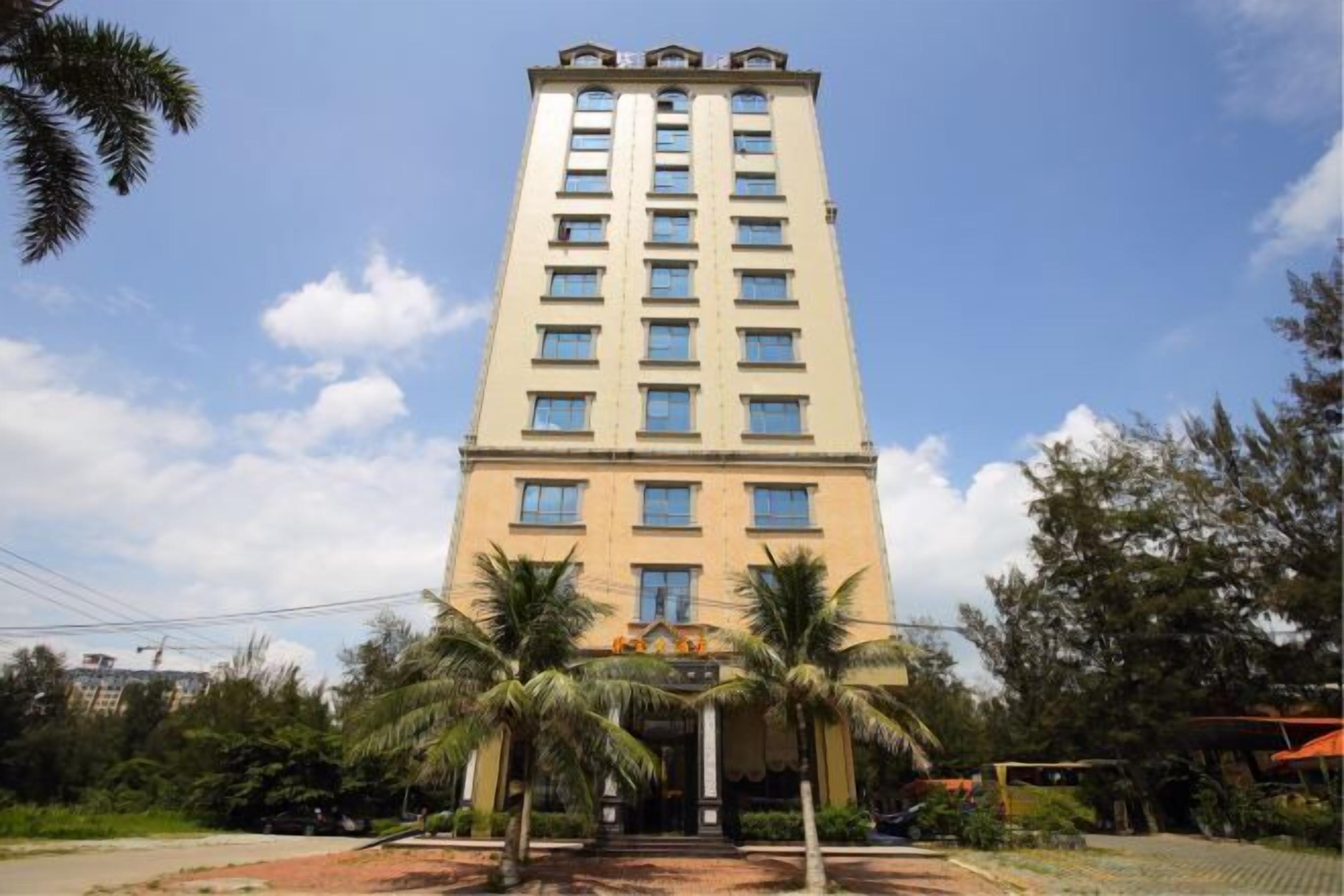 A tall, beige building with multiple windows and a central entrance.