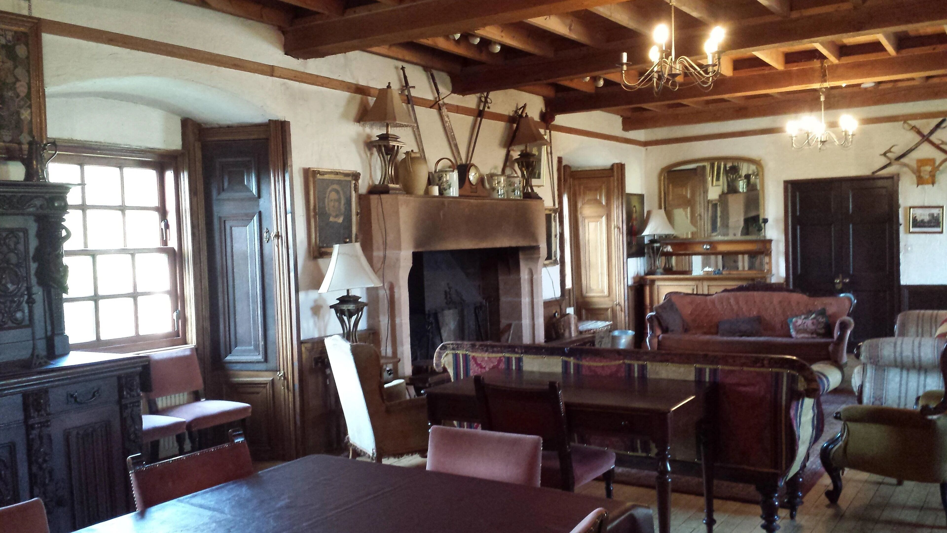 Une pièce de style traditionnel, dotée d’une cheminée, de meubles en bois et d’un lustre.