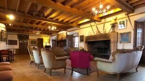 A spacious room with wooden floors, a fireplace, and several armchairs. - The Manor at Plane Castle - Sleeps 8 - Pets Ok (Falkirk)