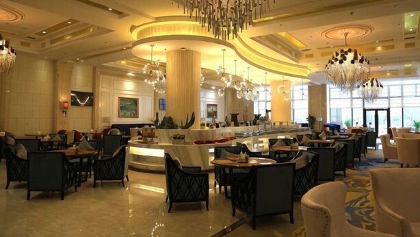 A spacious hotel lobby with multiple seating areas, a central bar, and large chandeliers. - Shenglin International Hotel (Gaobeidian)