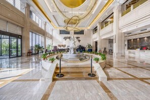 A spacious lobby with a central fountain, marble flooring, and a high ceiling with a golden chandelier. - Shenglin International Hotel (Gaobeidian)
