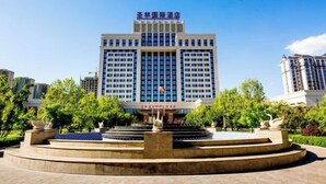 A modern hotel with a central courtyard, multiple floors, and a prominent entrance. - Shenglin International Hotel (Gaobeidian)