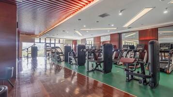 Una palestra con attrezzature per esercizi, pavimento in legno e un'ampia finestra.