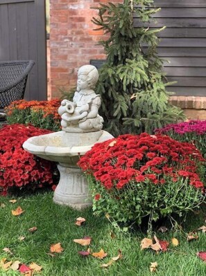 Stunning garden setting with a serene stone fountain and vibrant flowers.
