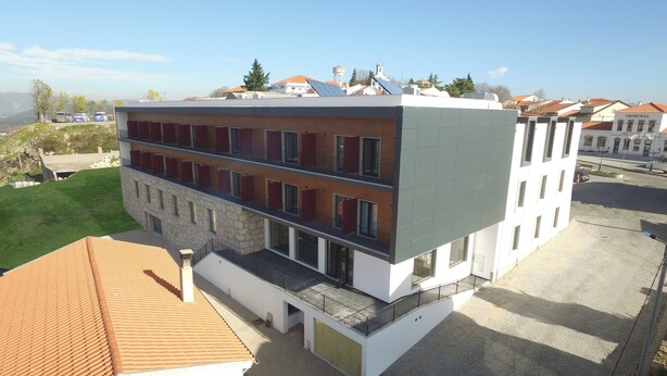 Un edificio a più piani con un design architettonico moderno, caratterizzato da balconi e ampie finestre.