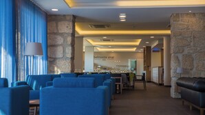 A hotel lobby with blue seating, stone walls, and a reception desk. - Belmonte Sinai Hotel (Belmonte)
