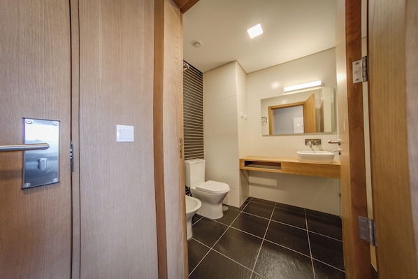Un baño con inodoro, lavabo y espejo.