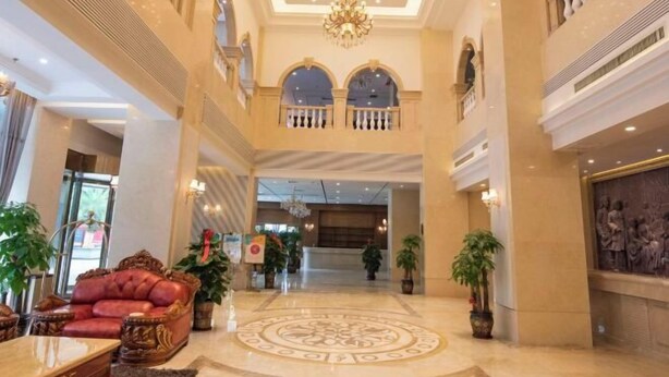 A spacious lobby with a grand chandelier, a red sofa, and a decorative floor pattern. - Venus Royal Hotel (Guilin Airport) (Guilin)