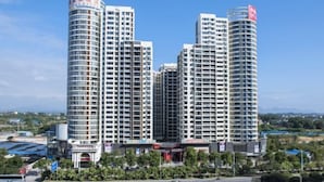 A modern hotel complex with multiple high-rise buildings, featuring a central courtyard with greenery and a small water feature. - Venus Royal Hotel (Guilin Airport) (Guilin)