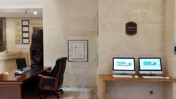 Une salle de conférence avec une longue table, deux écrans d’ordinateur et un fauteuil de bureau noir.