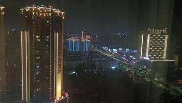 A high-rise building with illuminated vertical lines and a prominent sign.