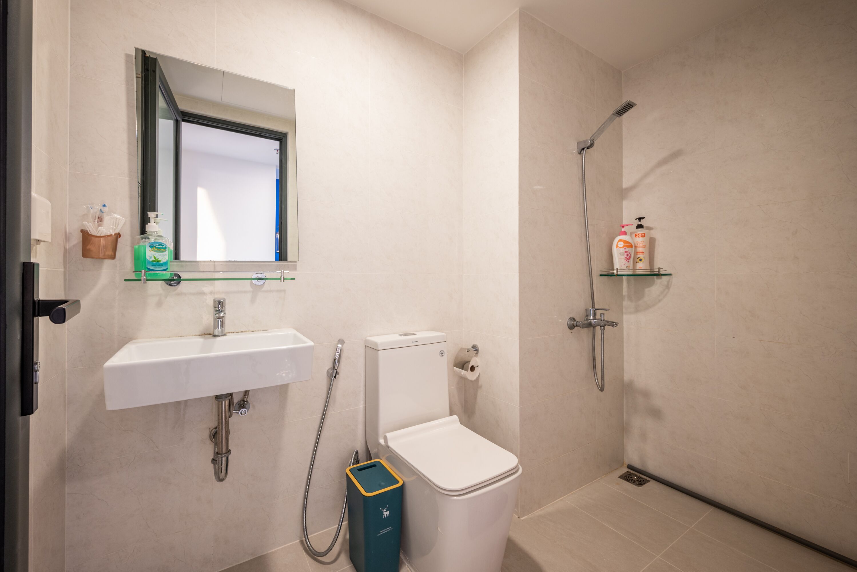 A modern bathroom with a white sink, toilet, and shower.