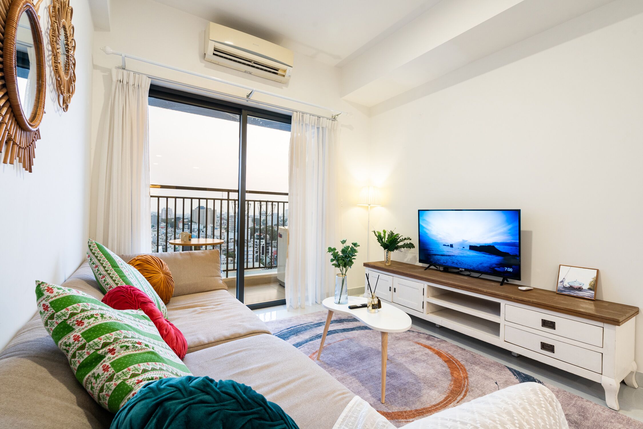 Una sala de estar moderna con sofá, televisor y balcón.
