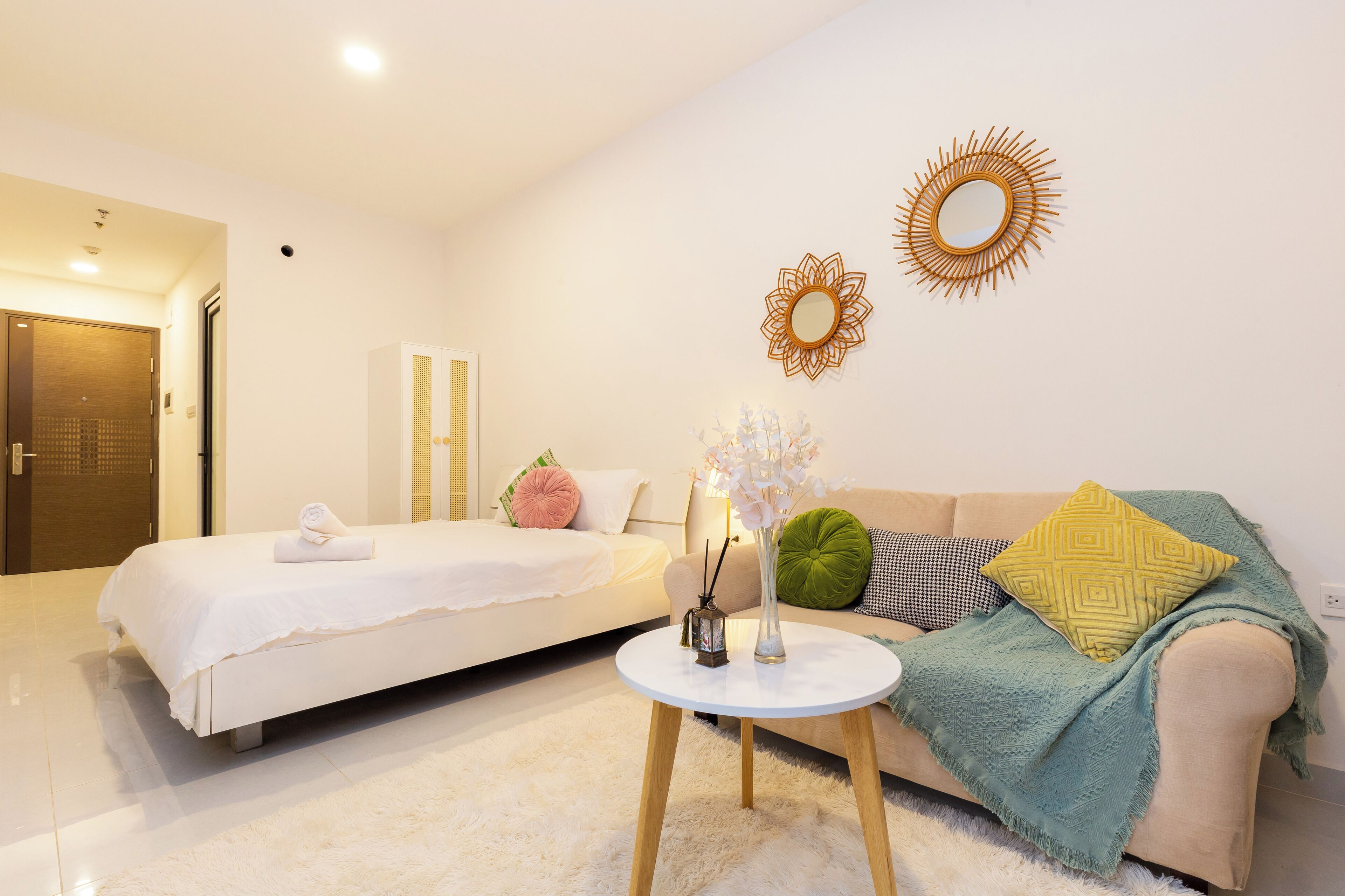 Una habitación de hotel moderna con una cama, un sofá, una mesa redonda y decoración mural.