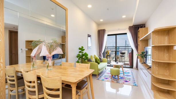 Ein modernes Wohnzimmer mit Essbereich, einer Couch und einem Balkon mit Blick.
