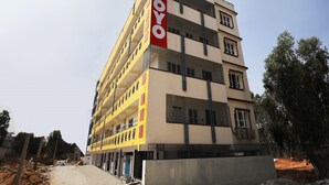 Un immeuble à plusieurs étages, reconnaissable à son grand panneau « OYO » sur le côté, doté de balcons et de nombreuses fenêtres.
