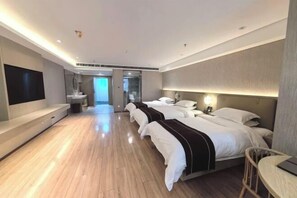 A modern hotel room with a large bed, a desk, and a TV.