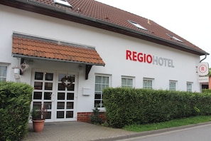 A hotel with a white facade, a tiled roof, and a sign reading 'REGIOHOTEL'. - Regiohotel Pfälzer Hof Wernigerode (Wernigerode)