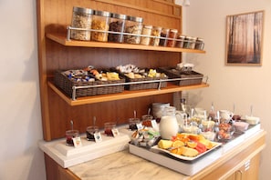 Un bufé de desayuno con una variedad de alimentos y acompañamientos.