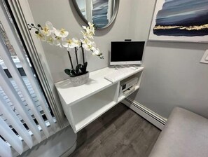 Work in style with a desk and computer, plus a beautiful orchid arrangement.